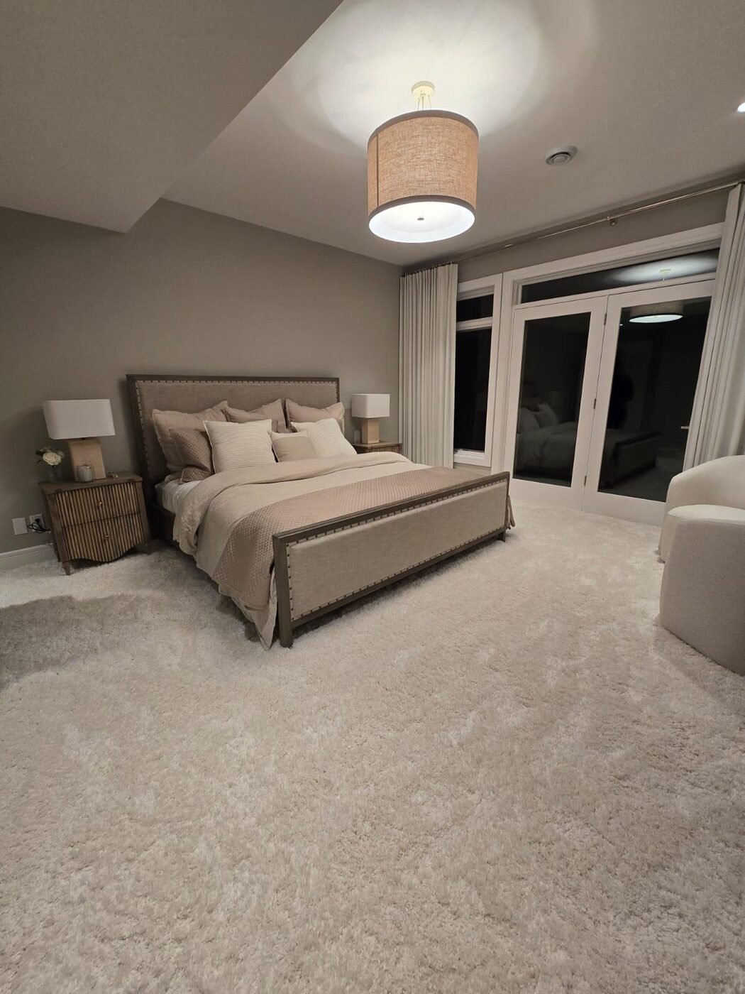 Master bedroom with upholstered bed and bedside tables, carpet vacuumed